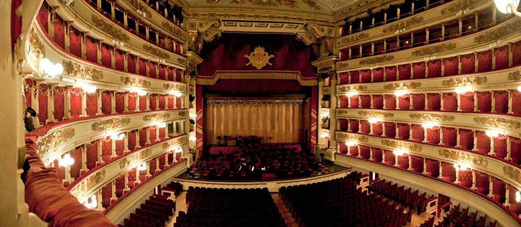Interno del Teatro alla Scala di Milano con palchi rossi e palcoscenico storico